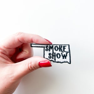May include: White embroidered patch shaped like the state of Oklahoma with the text "SMOKE SHOW" in black.