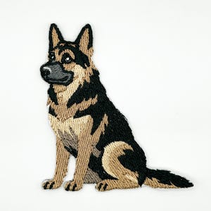 May include: An embroidered patch featuring a German Shepherd dog in a sitting position. The dog has a black and tan coat with pointed ears, a dark muzzle, and a detailed stitched texture throughout the design, showcasing the breed's features.