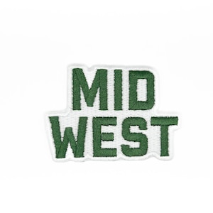 May include: Embroidered patch with the words "MID WEST" in green thread on a white background. The patch has a rectangular shape with rounded corners and a stitched border.