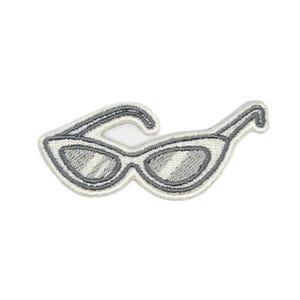 May include: A white ceramic mug with a black handle and the text "But First, Coffee" in a bold, black font. The mug is set against a blurred background, suggesting a cozy setting.