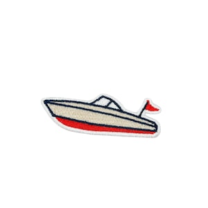 May include: An embroidered patch shaped like a motorboat with a cream-coloured hull, a dark blue trim, a red bottom, and a small red flag attached to the stern. The design features a dark blue windscreen outline and a white border edge.