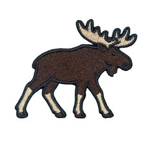 May include: An embroidered patch in the shape of a moose. The moose has a dark brown body, light beige antlers, and light beige lower legs. The entire design is outlined in a thick black thread, creating a clear silhouette of the animal.