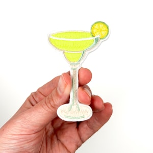 May include: A yellow embroidered iron-on patch of a margarita glass with a lime wedge.