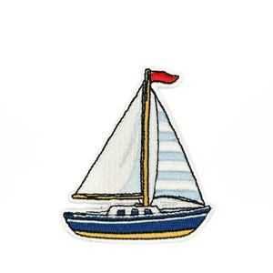 Peut inclure: Écusson brodé d'un voilier avec une voile blanche et une voile rayée bleue et blanche. Le bateau est bleu avec une bande jaune en bas. Un drapeau rouge flotte sur le mât.