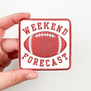 May include: Red and white embroidered iron-on patch with a football and the text "Weekend Forecast".
