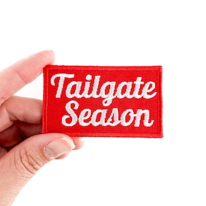 May include: Red fabric patch with white embroidered text that reads "Tailgate Season".