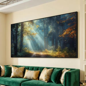 Peut inclure: Une impression murale rectangulaire représentant une forêt avec de grands arbres, de la lumière dorée filtrant à travers la canopée et des feuilles d'automne éparpillées au sol. L'œuvre est encadrée d'un fin cadre noir et fixée au mur.