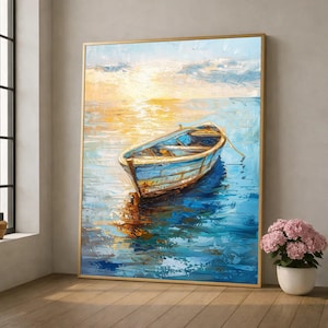 May include: Oil painting of a blue rowboat floating on water, reflecting the golden light of the setting sun. The artwork is framed in a gold-colored frame, with a vase of pink flowers in the foreground.