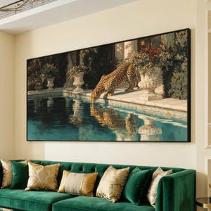 Könnte beinhalten: Ein rechteckiger Wandkunstdruck, der einen Leoparden zeigt, der aus einem Steinbecken trinkt. Die Szene umfasst klassische Steinkübel mit roten Blumen, dunkelgrünem Laub und die Spiegelung des Leoparden im tiefblauen Wasser, schwarz gerahmt.