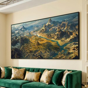 May include: A rectangular wall art print featuring a panoramic landscape illustration of a vast mountain range, a winding blue river, and stone structures nestled within the terrain, all enclosed in a thin black frame.