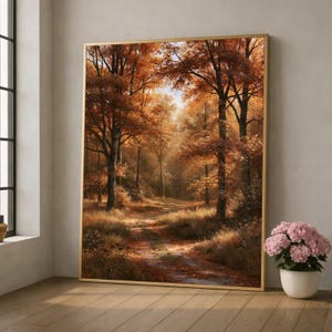 Könnte beinhalten: Ein rechteckiger Wandkunstdruck in einem dünnen goldenen Rahmen, der einen Waldweg im Herbst zeigt. Die Szene umfasst hohe Bäume mit leuchtend orangefarbenem und braunem Laub, einen mit Blättern bedeckten Pfad und sanftes Sonnenlicht.