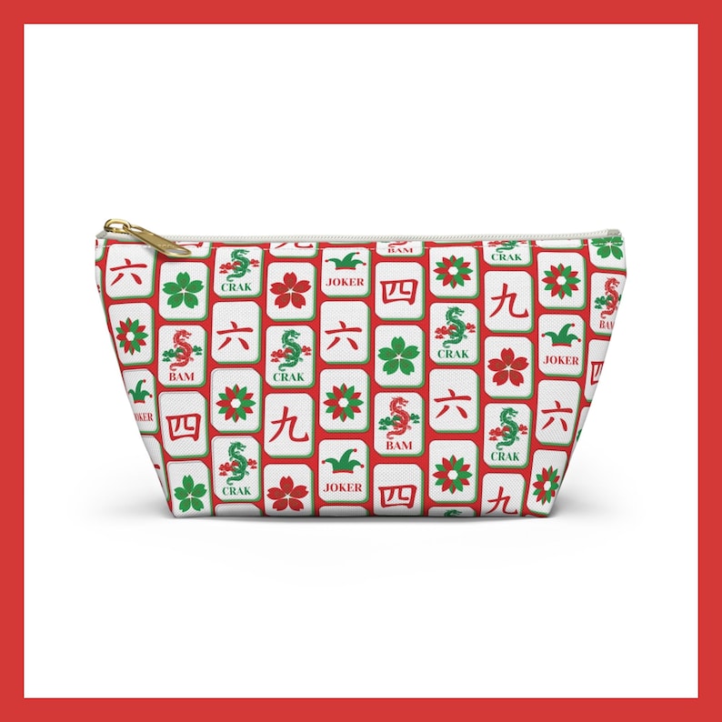 May include: White zippered pouch with a repeating pattern of red, green, and white Mahjong tiles. The tiles feature Chinese characters, flowers, and dragons. The pouch has a gold zipper.