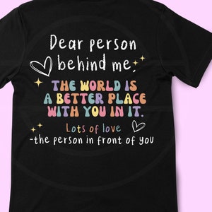 Puede incluir: Camiseta negra con un gráfico blanco que dice "Querida persona detrás de mí. El mundo es un lugar mejor contigo en él. Mucho amor -la persona delante de ti"