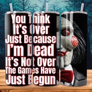 Könnte beinhalten: Ein schwarzer und roter Edelstahlbecher mit dem Text "You Think It's Over Just Because I'm Dead It's Not Over The Games Have Just Begun". Der Becher zeigt eine Grafik eines Charakters aus dem Horrorfilm Saw.