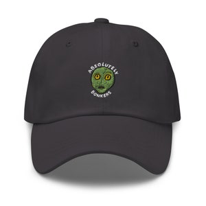 Op de afbeelding: Een donkergrijze baseballpet met een geborduurd groen alien gezicht en de tekst "ABSOLUTELY BONKERS" in wit.