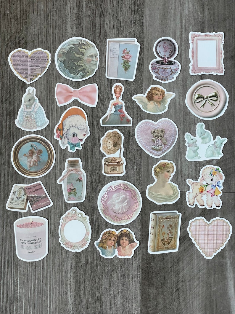 May include: A selection of vintage-style stickers with diverse designs, such as cherubs, a lamb, a doll, a bow, a moon face, a heart, a book, and a candle. The stickers have a soft, pastel colour palette with pink, blue, and cream tones.