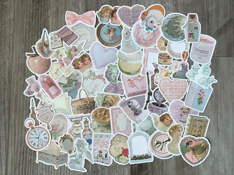 May include: A selection of pastel-coloured, vintage-style stickers. The stickers depict cherubs, hearts, bows, and other decorative elements. Some stickers include text, such as "Summer in Scotland" and "The Dreams of a Pink Christmas."