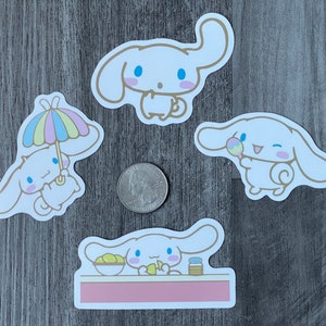 Pu&ograve; includere: Quattro adesivi bianchi di personaggi dei cartoni animati con accenti azzurri e contorni dorati. Un adesivo raffigura il personaggio sotto un ombrello colorato. Un altro tiene in mano un lecca-lecca. Una moneta &egrave; accanto agli adesivi.
