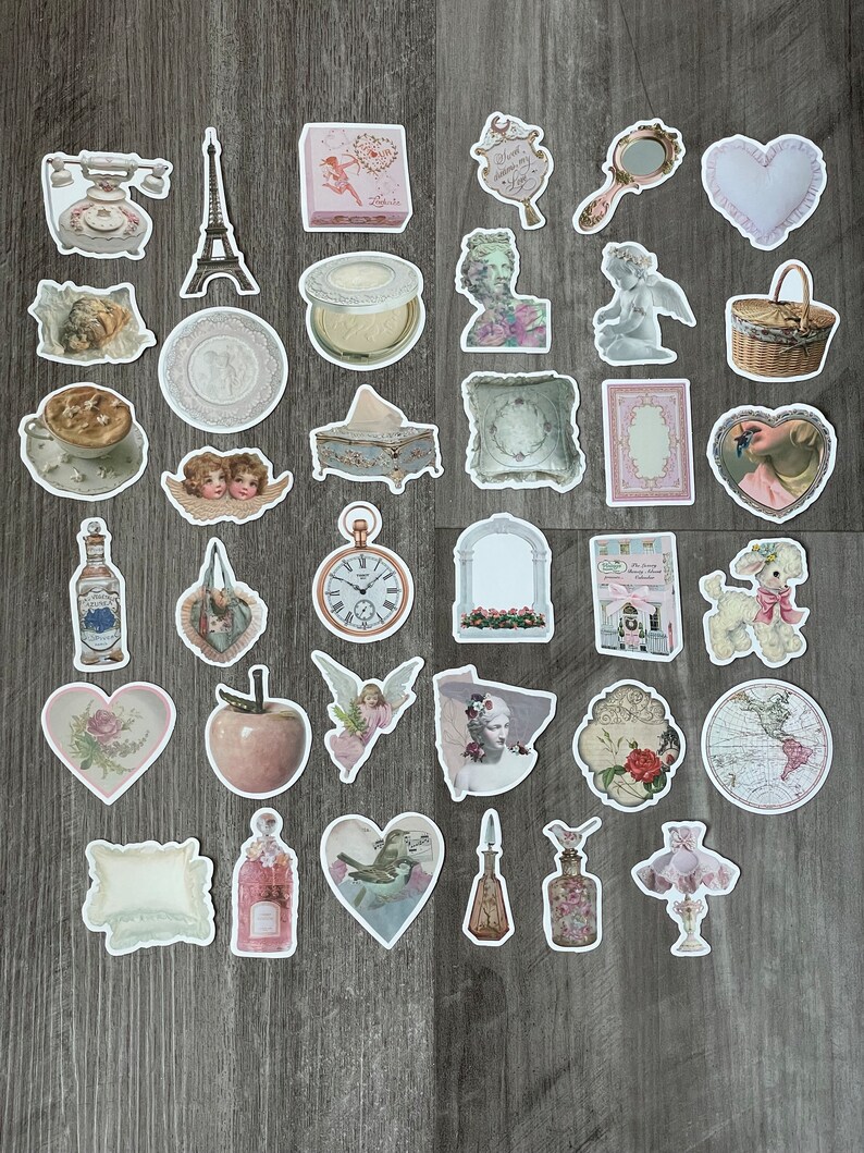May include: A selection of vintage-style stickers with diverse designs. Includes images of an Eiffel Tower, cherubs, a pocket watch, perfume bottles, hearts, and a poodle. The stickers have a soft, pastel colour palette with floral and antique elements.