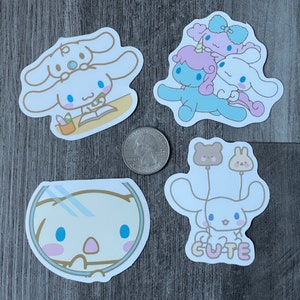 Pu&ograve; includere: Quattro adesivi fustellati con personaggi dei cartoni animati. Un adesivo mostra un personaggio con papillon e libro, un altro ha un gruppo di personaggi, un terzo mostra un personaggio in una boccia per pesci e l'ultimo ha un personaggio con palloncini e la parola "CUTE".
