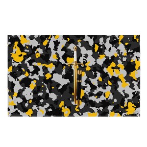 Peut inclure: Un drapeau rectangulaire arborant un motif camouflage dans des tons de noir, gris et jaune. Au centre du drapeau se trouve une épée dorée avec une poignée blanche, placée verticalement à côté d'un fourreau noir et doré assorti.