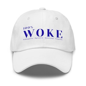 May include: White baseball cap with the text "100% WOKE" in blue. Below the word "WOKE" are the words "Willingness, Openness, knowledge, Empathy". The cap has a curved brim and an adjustable strap.