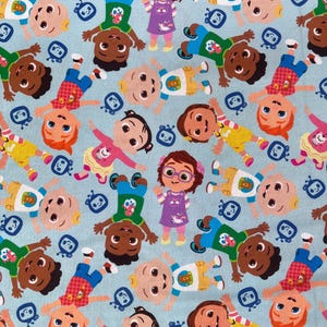Op de afbeelding: Een blauwe stof met een herhalend patroon van cartoonkinderen. De kinderen dragen verschillende gekleurde kleding en hebben verschillende kapsels. Er zijn ook kleine blauwe en witte televisies in het patroon.