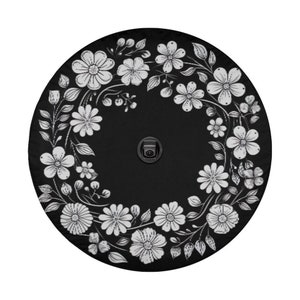 May include: Black round patio umbrella with a white floral design. The umbrella has a black metal pole and a white floral pattern around the edge.