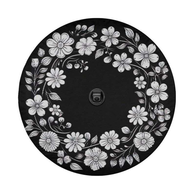 May include: Black round patio umbrella with a white floral design. The umbrella has a black metal pole and a white floral pattern around the edge.
