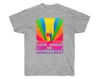 May include: A gray t-shirt with a rainbow design and two figures walking towards a bright yellow sun. The text "LOVE KNOWS NO BOUNDARIES" is printed in pink below the figures.