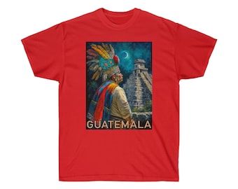 Puede incluir: Una camiseta roja con una ilustración colorida de un hombre maya con un tocado de plumas de pie frente a un templo maya. El texto "GUATEMALA" está impreso debajo de la ilustración.
