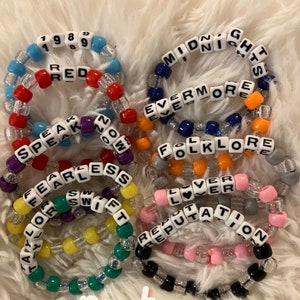 Pu&ograve; includere: Dieci braccialetti colorati con perline con i nomi degli album di Taylor Swift: 1989, Red, Speak Now, Fearless, Taylor Swift, Lover, Reputation, Folklore, Evermore e Midnights.
