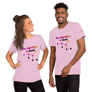 May include: Two people wearing pink t-shirts with a graphic design of a molecular structure and the text "the algorithm is dead".