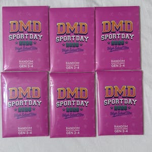 May include: Six identical rectangular pink packets featuring the text DMD SPORTDAY 2026 High School Vibes and RANDOM PHOTOCARDS GEN 3-4. The packaging has a repeating faint pattern of small figures and stars across the surface of each individual item.