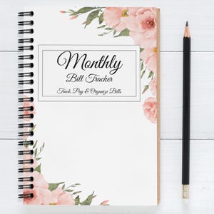 May include: A pink floral design covers the front and back of a spiral bound notebook. The front cover has a white rectangle with the text "Monthly Bill Tracker Track, Pay & Organize Bills".
