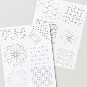 May include: Two sheets of paper with different geometric patterns printed on them. The patterns include circles, hexagons, squares, zigzags, and dots.