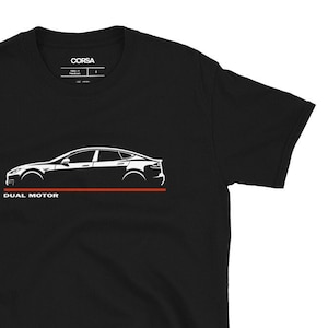 May include: Black t-shirt with a white graphic of a car's side profile, a red line, and the text "DUAL MOTOR". The shirt also has the brand name "CORSA" printed on the upper part.
