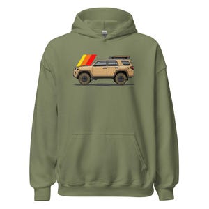 May include: Olive green hoodie featuring a graphic of a tan SUV with a roof rack and a retro-style stripe design in yellow, orange, and red. The SUV has black wheels and tires. The hoodie has a drawstring hood and a kangaroo pocket.