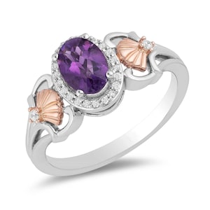 May include: A silver ring featuring a central oval-cut purple amethyst stone surrounded by a halo of small white diamonds. The band includes two rose gold fan-shaped accents on either side, each set with a single small white diamond.