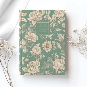 Op de afbeelding: Een tealblauw notitieboek met een bloemenpatroon in crème en bruin. De tekst "Eliza Johnson Church Sermons" staat op de voorkant gedrukt.
