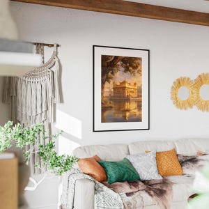 May include: A framed print of a golden building with a reflection in the water. The print is hanging on a white wall with a macrame wall hanging and three woven straw sunburst mirrors.