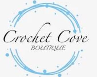 May include: The Crochet Cove Boutique logo features elegant cursive text within a light blue circle. The words "Crochet Cove" are in a stylish script, with "BOUTIQUE" in a smaller, sans-serif font below.