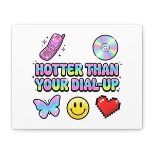 May include: A white canvas print featuring a retro design with a flip phone, CD, butterfly, smiley face, and pixelated heart. The text "HOTTER THAN YOUR DIAL-UP" is displayed in colorful bubble letters, evoking a nostalgic aesthetic.