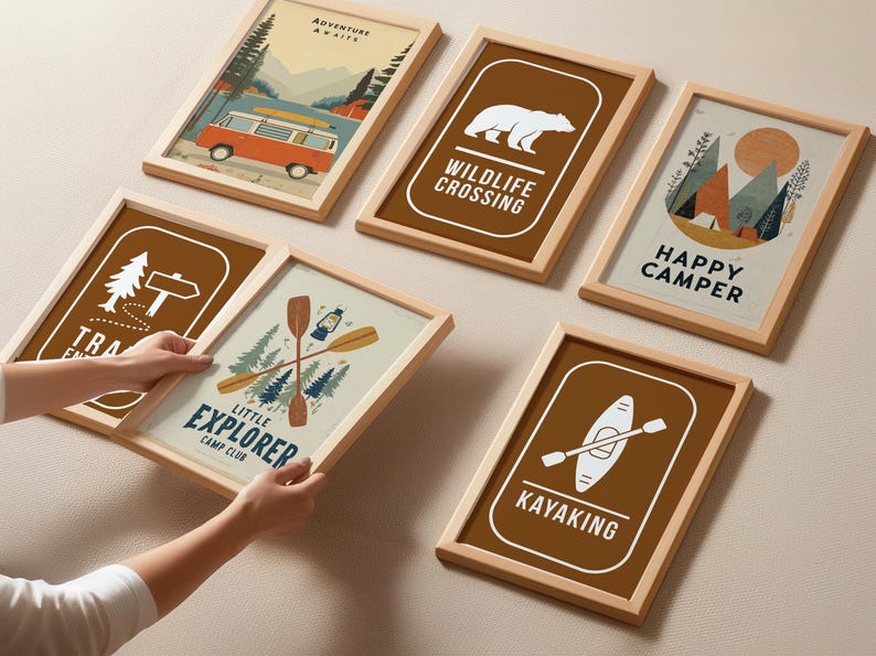 Puede incluir: Una colecci&oacute;n de l&aacute;minas enmarcadas con tem&aacute;tica de camping. Las l&aacute;minas presentan ilustraciones de una furgoneta camper, un oso, monta&ntilde;as y equipo de camping. La paleta de colores incluye marr&oacute;n, beige, naranja y azul. El texto incluye "Adventure Awaits", "Wildlife Crossing", "Happy Camper", "Little Explorer Camp Club", "Kayaking".