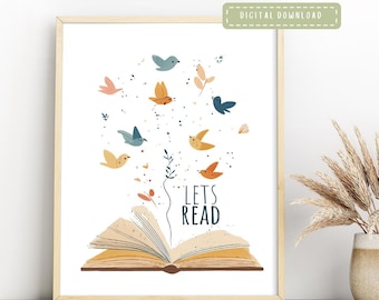 May include: A framed print featuring an open book with colorful birds flying out. The words "LETS READ" are written below the birds. The print has a digital download label.