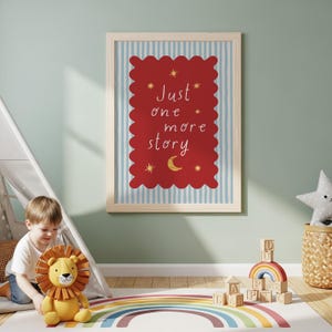 A child is sitting on the floor in a colorful playroom, surrounded by toys and a framed poster with a red background and a white border.