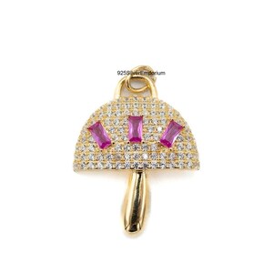 Peut inclure: Un pendentif champignon doré dont le chapeau est incrusté de nombreuses petites pierres de zircone cubique transparentes et de trois pierres roses rectangulaires taille baguette. La tige est en métal doré lisse avec une boucle. Texte 925SilverEmporium.