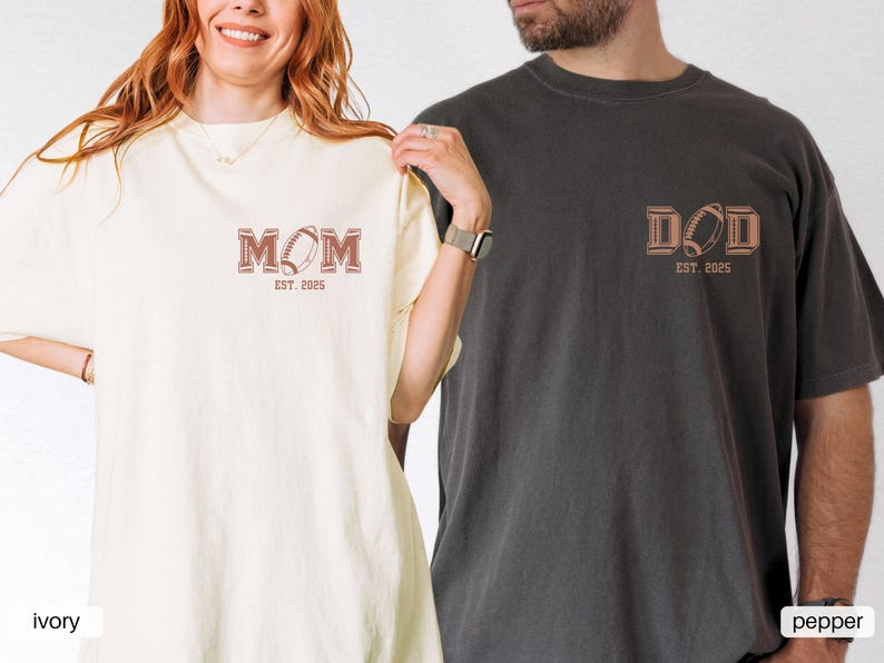 May include: Two t-shirts, one ivory and one pepper, with the words "MOM EST. 2025" and "DAD EST. 2025" printed on them. Each shirt features a football graphic.