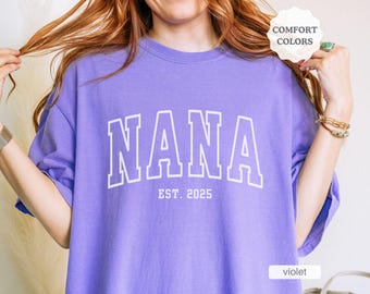 May include: A purple t-shirt with the word "NANA" in white outlined letters and the text "EST. 2025" underneath.