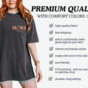May include: A black t-shirt with the text "MOMA EST. 2005" printed on the front. The shirt is made with high-quality fabric and is eco-friendly. It is also durable and long-lasting.